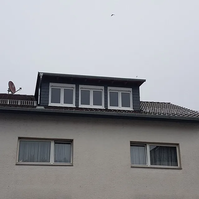 Haus mit Dachgaube mit drei Fenstern