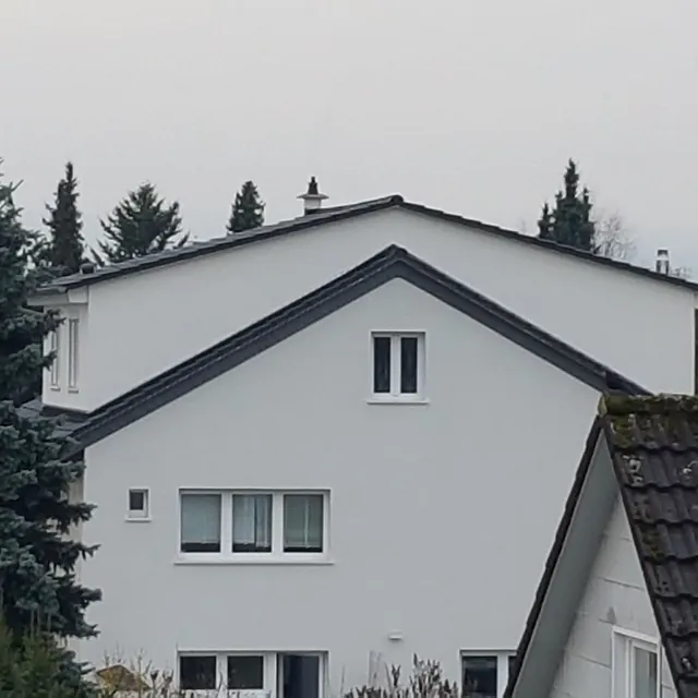 Hausgiebel eines grau gestrichenen Hauses